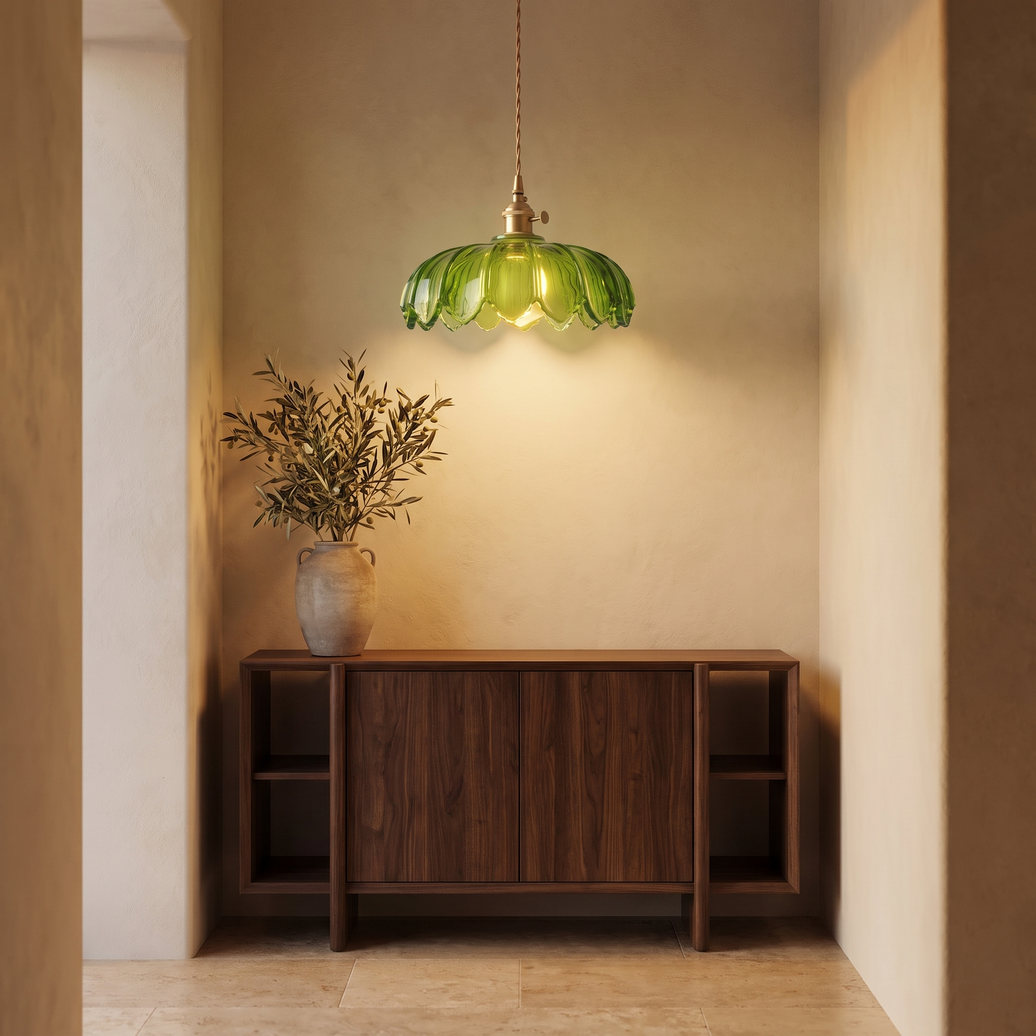 Fiora green glass flower pendant hanging above a walnut console in a plaster entryway