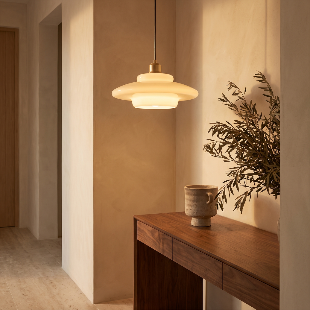 Lattea milk glass pendant hanging above a walnut console in a plaster hallway nook