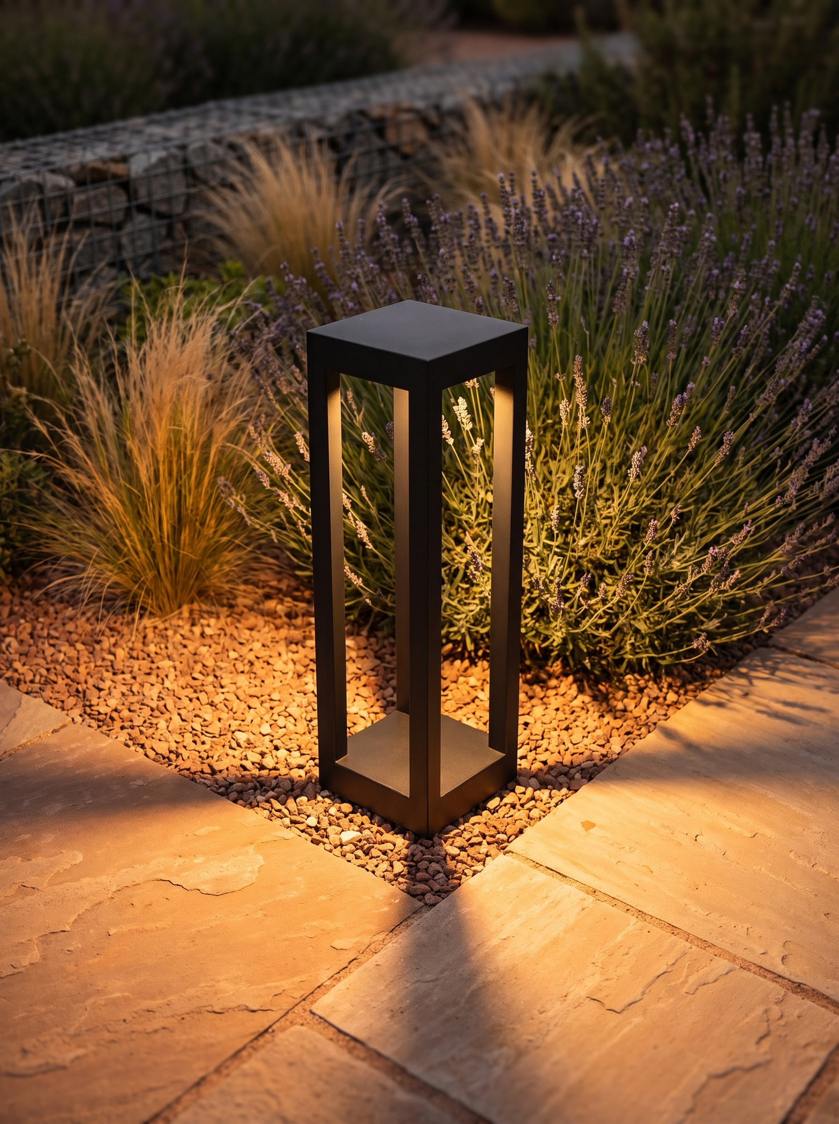 Stelo bollard light spilling warm light in several directions across paving