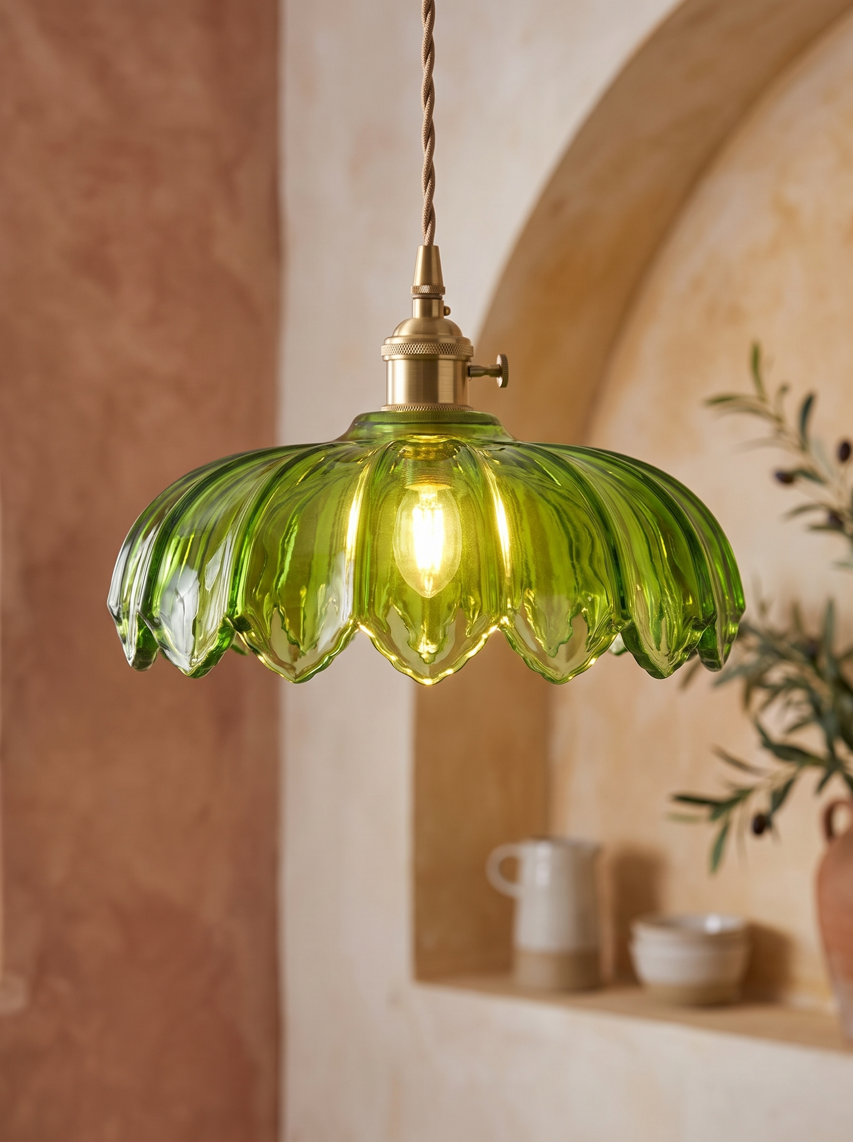 Fiora pendant with warm light passing evenly through the saturated green glass