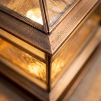 Macro detail of the glazed top cap and copper joinery on the Rame pillar light
