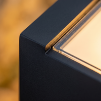 Macro detail of the cast aluminum body and glass diffuser seam on the Stelo bollard light