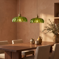 A pair of Fiora green glass flower pendants above a walnut dining table